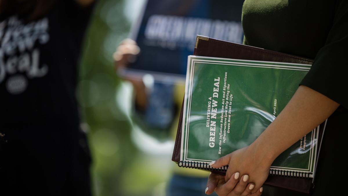 Picture of Congresswoman's holding the Green New Deal implementation guide