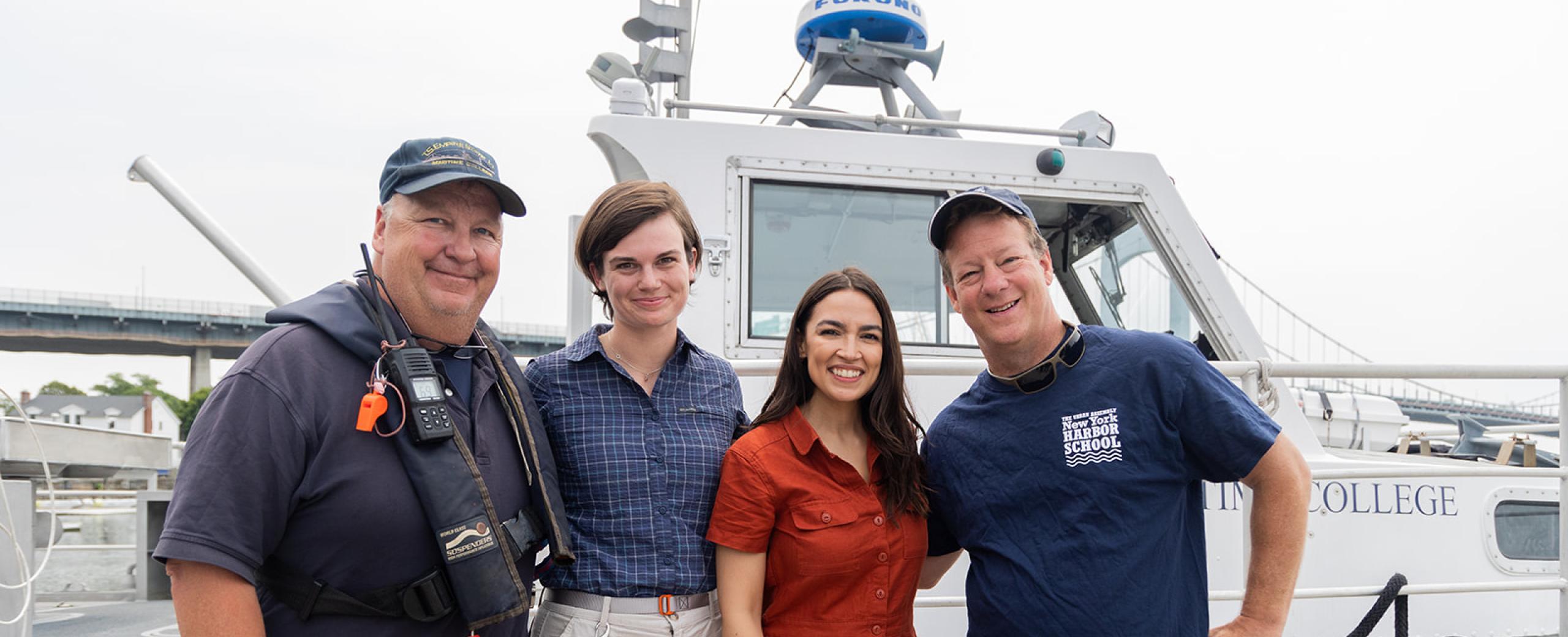 Rep. AOC stands with workers in front of a boat